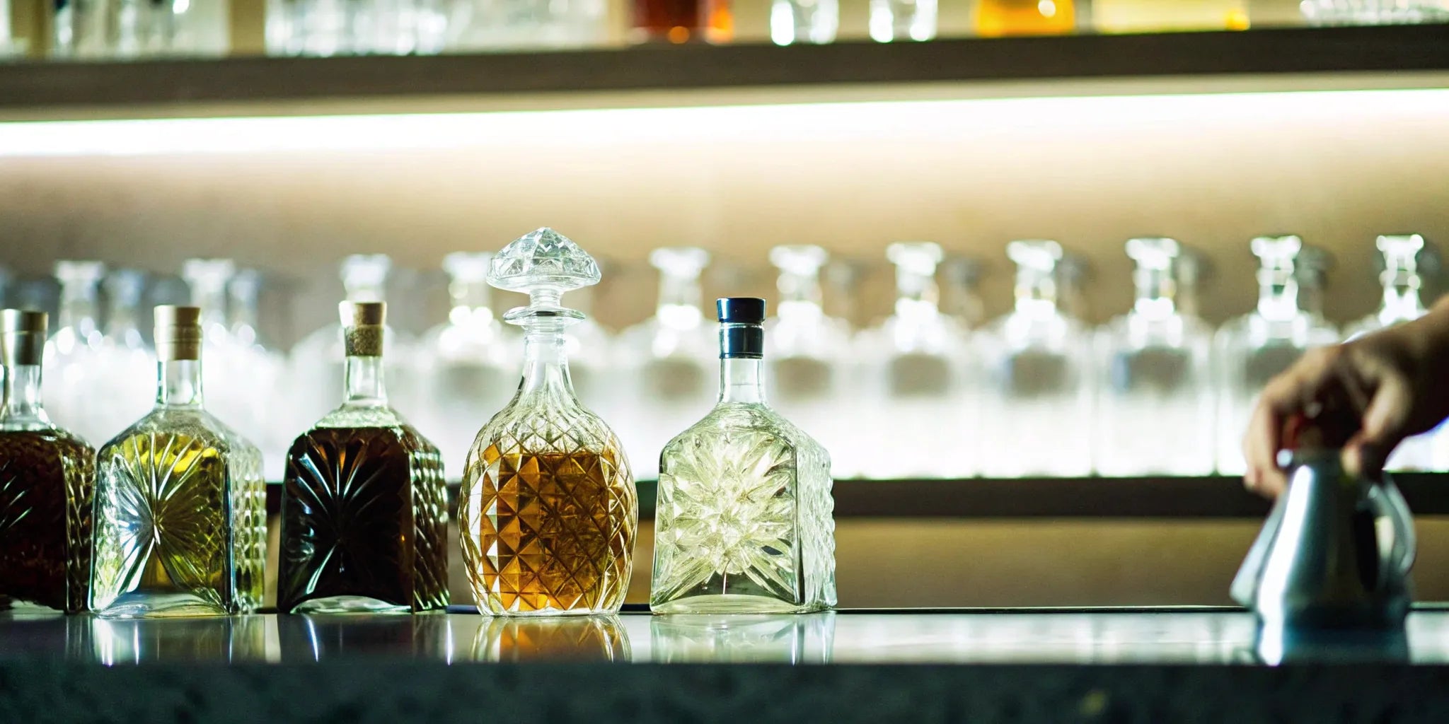 Bottles of the best tequilas according to bartenders, lined up on a bar.