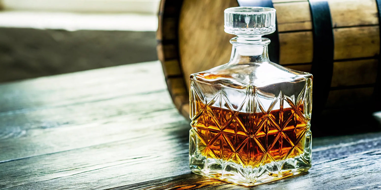 Bottle of Compoveda Extra Anejo tequila on a dark wooden table with warm amber lighting