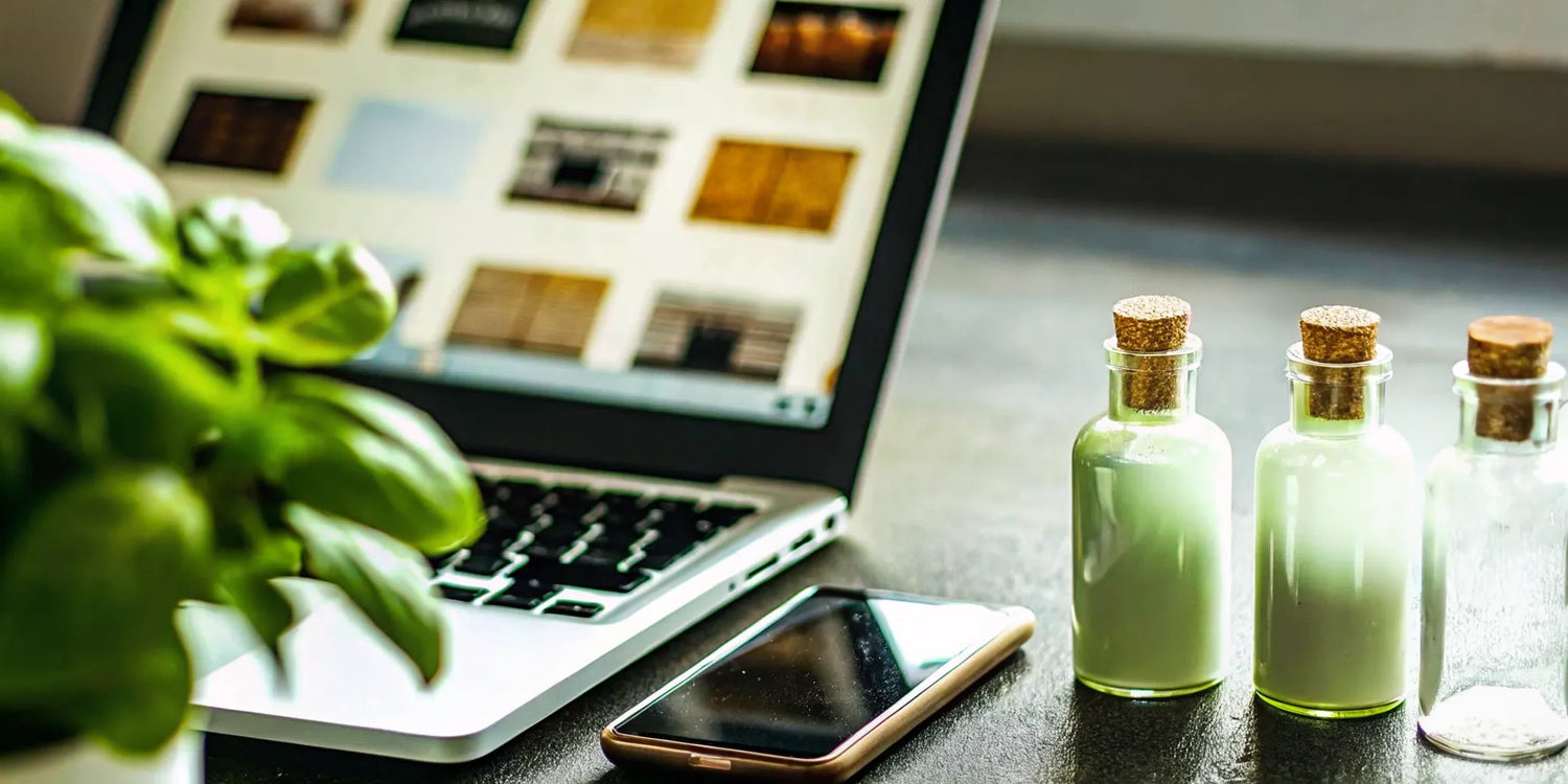 Shopping to buy small batch mezcal online with a laptop and several bottles.