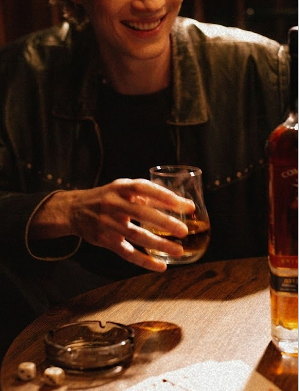 personal holding a glass of anejo tequila